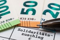Foto: Schriftzug Solidaritätszuschlag und Geldscheine